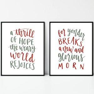 May include: Two printable wall art prints with inspirational quotes. The first print has the text "a thrill of hope the weary world rejoices" in green and red lettering. The second print has the text "for yonder breaks a new and glorious morn" in red lettering.