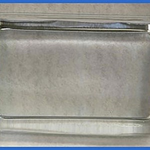 Puede incluir: Una caja rectangular de vidrio transparente con una superficie lisa y pulida. La caja está vacía y tiene un borde ligeramente redondeado.