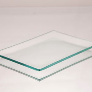 May include: Two clear glass rectangular trays stacked on top of each other. The trays have a slight green tint to the edges.