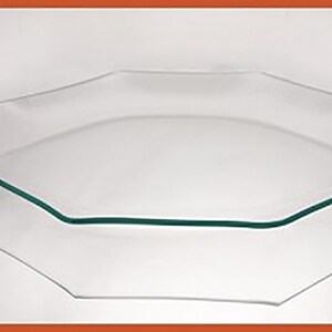 May include: A clear glass octagonal serving platter with a green rim. The platter is stacked on top of a similar but slightly larger platter.