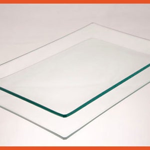 May include: Two clear glass rectangular trays stacked on top of each other. The trays have slightly rounded edges.