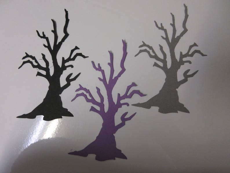 Pode incluir: Tr&ecirc;s recortes de papel de &aacute;rvores nuas em preto, cinza e roxo. As &aacute;rvores t&ecirc;m todas a mesma forma, mas tamanhos diferentes. Todas est&atilde;o sobre um fundo branco.
