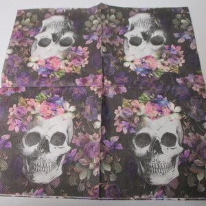 Peut inclure: Quatre motifs de cr&acirc;nes noirs et blancs avec des couronnes de fleurs sur un fond violet fonc&eacute;. Les cr&acirc;nes sont entour&eacute;s de fleurs roses, violettes et blanches.