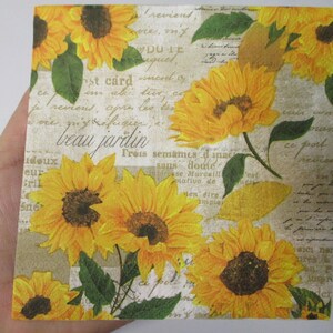 May include: A vintage-style paper napkin with a repeating pattern of yellow sunflowers and green leaves on a beige background. The text "beau jardin" is printed in black cursive script.