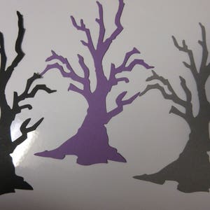 Pode incluir: Tr&ecirc;s recortes de papel de &aacute;rvores nuas. As &aacute;rvores est&atilde;o em diferentes tons de roxo, cinza e preto. As &aacute;rvores t&ecirc;m todas a mesma forma e tamanho.