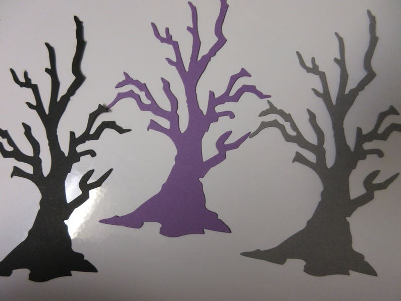 Pode incluir: Tr&ecirc;s recortes de papel de &aacute;rvores nuas. As &aacute;rvores est&atilde;o em diferentes tons de roxo, cinza e preto. As &aacute;rvores t&ecirc;m todas a mesma forma e tamanho.