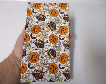May include: White fabric with a repeating pattern of black cats wearing witch hats, orange pumpkins, and spiderwebs.