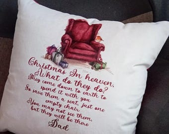 Puede incluir: Cojín decorativo blanco con una ilustración de acuarela de un sillón rojo, regalos y texto. El texto dice "Christmas In heaven, What do they do?" y continúa con un poema sobre seres queridos.