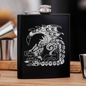 May include: Black metal flask with a silver cap and a laser-etched design of a dragon with intricate details.