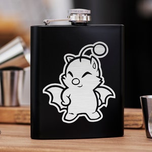 May include: Black metal flask with a silver cap and a white graphic of a cartoon creature with wings and a smiling face.