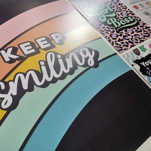 May include: A black background with a rainbow arc and the text "KEEP smiling" in white. The rainbow is made up of pink, orange, yellow, green, blue, and purple stripes.