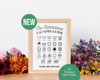 May include: A framed black and white laundry guide with the text "The Richardsons Laundry Guide" and a variety of laundry symbols. The guide also includes the text "WASH, DRY and FOLD" and "THE Curious - PRINT STUDIO -" at the bottom.