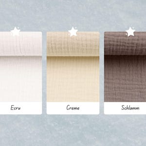 May include: Three fabric swatches in different colors: ecru, creme, and schlamme. The swatches are rolled up and have a textured, gauze-like appearance.