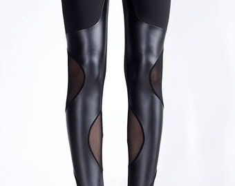 May include: Black leggings with a faux leather panel and mesh inserts. The leggings are fitted and have a high waist.
