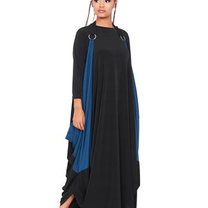 May include: A black maxi dress with a blue panel and silver rings on the straps. The dress has a loose, flowing fit.