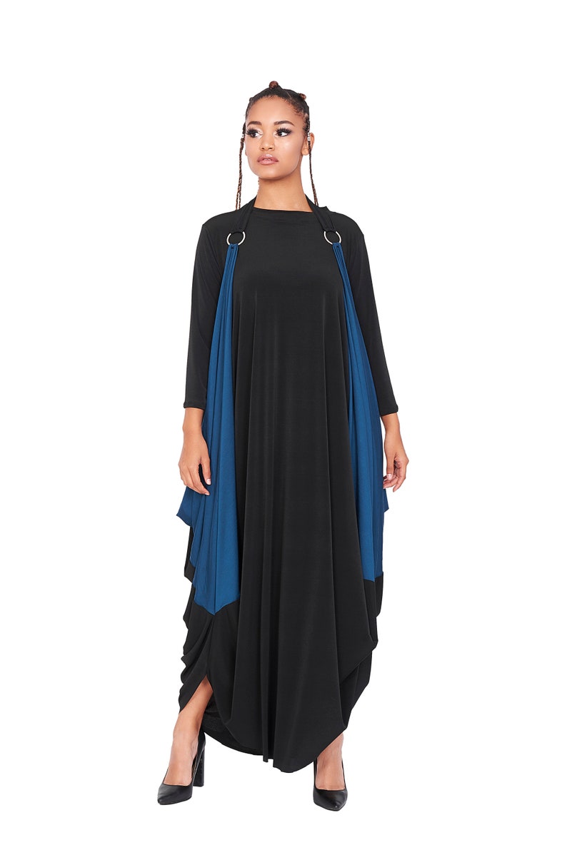 May include: A black maxi dress with a blue fabric overlay and silver rings at the shoulders. The dress has a loose, flowing fit and a gathered hem.
