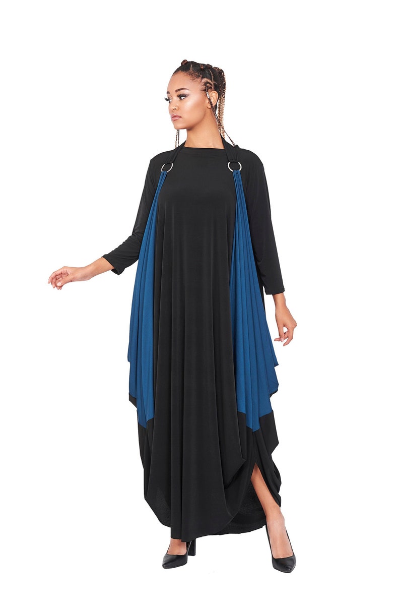 May include: A black and teal maxi dress with a draped design and silver rings at the shoulders.