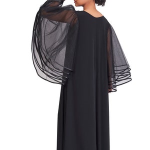 May include: A floor-length black dress featuring sheer, voluminous bell sleeves made of layered tulle fabric. The sleeves are accented with multiple horizontal bands of black trim at the cuffs, creating a tiered effect on this solid black garment.