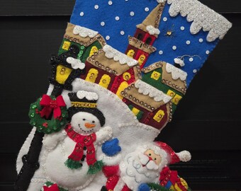 Handgestikte kerstsok Kerstdorp / Santa is Here BUCILLA