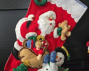 Handgestikte kerstsok van bucillavilt: kerstman, sneeuwpop en cadeaus