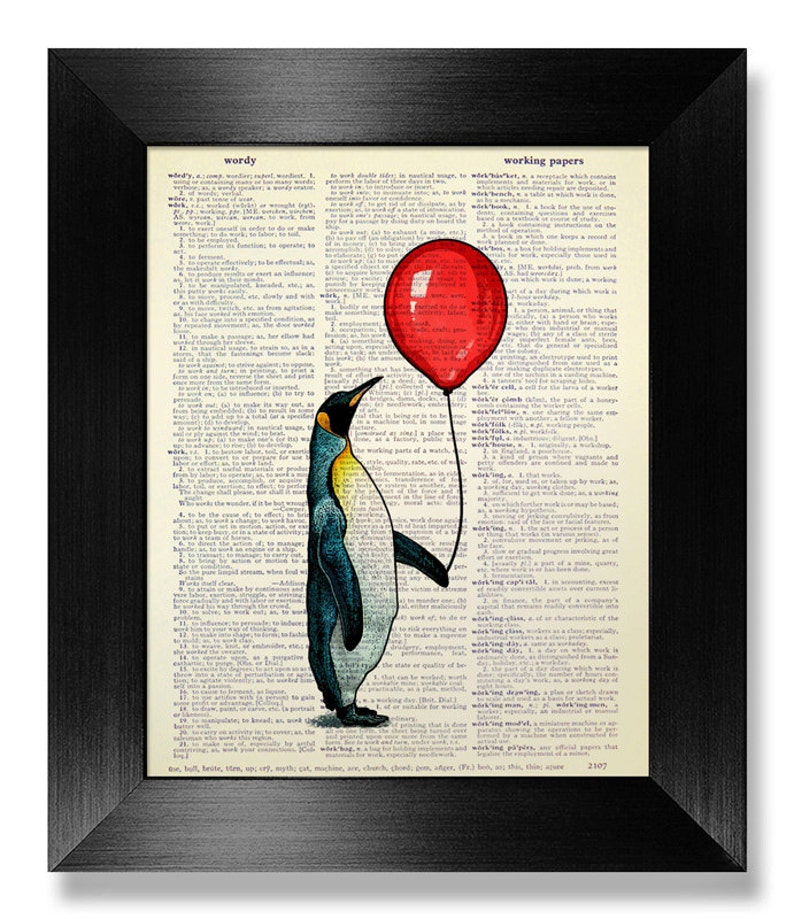 May include: Framed art print featuring a penguin holding a red balloon. The penguin illustration is set against a vintage dictionary page background. The black frame adds a classic touch to the artwork.