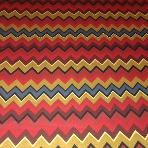 May include: Red, brown, gold, and blue chevron pattern fabric. The fabric has a repeating pattern of zigzags.