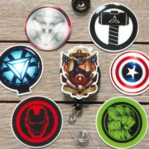 May include: Set of nine round, colorful, printed, adhesive backed buttons featuring various Marvel superhero characters. The buttons include Captain America, Iron Man, Thor, Hulk, and the Avengers logo. The buttons are approximately 2 inches in diameter.