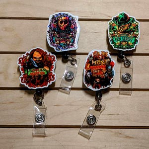 May include: Four colorful Halloween themed retractable badge holders with different horror movie characters. The badge holders feature images of Jason Voorhees, Freddy Krueger, Chucky, and a group of horror movie characters. The text on the badge holders reads "Welcome to Crystal Lake", "Welcome to Elm Street", "It's the Most Wonderful Time of the Year", and "Welcome to Halloween".