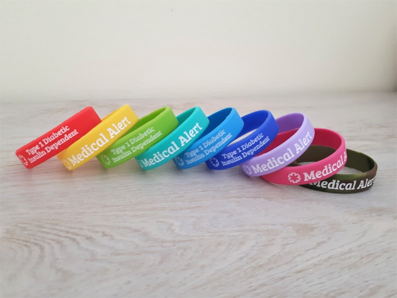 Peut inclure: Un ensemble de huit bracelets en silicone color&eacute;s avec le texte "Medical Alert" et "Type 1 Diabetic Insulin Dependent" imprim&eacute; en blanc. Les bracelets sont dispos&eacute;s en arc-en-ciel, en commen&ccedil;ant par le rouge et en terminant par le vert.