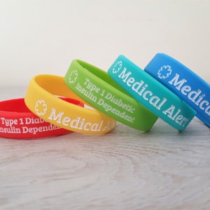 Peut inclure: Quatre bracelets d'alerte m&eacute;dicale en silicone de couleurs vives avec du texte blanc. Les bracelets indiquent "Alerte m&eacute;dicale" et "Diabetique de type 1 d&eacute;pendant de l'insuline".