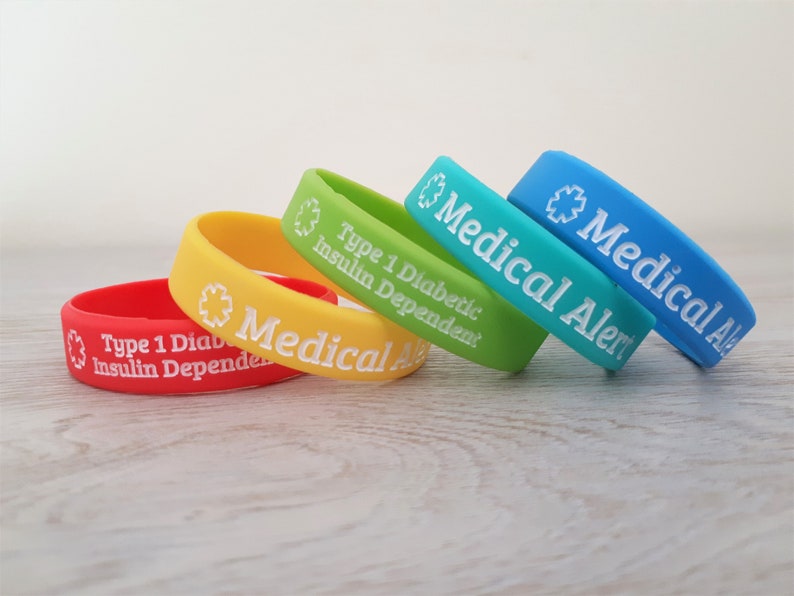 Peut inclure: Quatre bracelets d'alerte m&eacute;dicale en silicone de couleurs vives avec du texte blanc. Les bracelets indiquent "Alerte m&eacute;dicale" et "Diabetique de type 1 d&eacute;pendant de l'insuline".