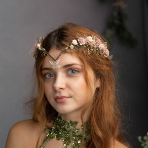 Peut inclure: Une femme aux longs cheveux roux ondul&eacute;s porte une couronne florale verte et dor&eacute;e avec un accent papillon. Elle porte un corsage vert et dor&eacute; &agrave; paillettes avec un collier assorti.