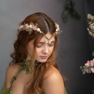 Peut inclure: Une femme aux longs cheveux roux porte une robe verte orn&eacute;e de fleurs. Elle porte une couronne florale d&eacute;licate avec un accent papillon sur son front.