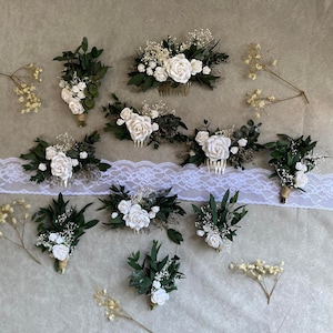 Puede incluir: Un surtido de accesorios florales nupciales, que incluyen peinetas y boutonnieres. Las piezas presentan rosas blancas, vegetaci&oacute;n y paniculata. Las boutonnieres est&aacute;n envueltas con hilo de bramante y las peinetas tienen un acabado dorado.