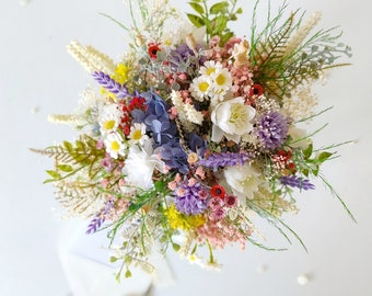 May include: A colourful bouquet of mixed flowers, including white daisies, purple hydrangeas, and yellow accents. The arrangement features greenery and various textures, creating a full, vibrant display. The bouquet is tied with a white ribbon.