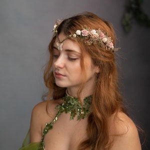 Peut inclure: Une femme aux longs cheveux roux porte une robe verte &agrave; paillettes et une couronne florale avec un accent papillon. La couronne est faite de fleurs d&eacute;licates et de verdure.
