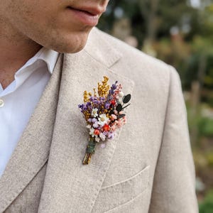 Boutonnière de pradera colorida: accesorio para el novio, boda en el jardín