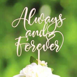 May include: Wooden cake topper with the words "Always and Forever" in a cursive font. A small heart is included in the design.