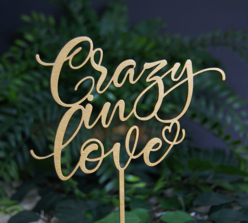 Pu&ograve; includere: Topper per torta in legno color oro con le parole "Crazy in Love" in un font corsivo. Il topper presenta un piccolo simbolo di cuore.