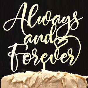 May include: White cake topper with the words "Always and Forever" in a cursive font with a heart symbol between the words.