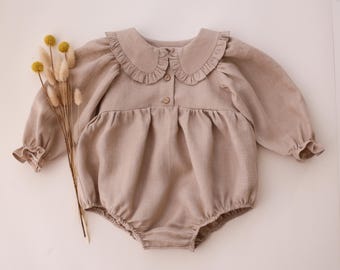 Pelele de bebé de lino beige con cuello con volantes y manga larga.