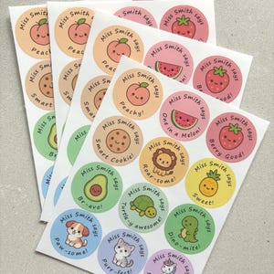 May include: A collection of circular sticker sheets featuring various cartoon characters and fruits. Each sticker includes the text Miss Smith says followed by a pun such as Peachy, Smart Cookie, Br-avo, Paw-some, Purr-fect, One in a melon, Berry Good, Roar-some, Turtle-y awesome, Sweet, Dino-mite, and Magical Work.