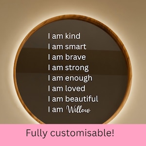 May include: A circular wall sign with a wooden frame and a dark background featuring white text that reads: I am kind, I am smart, I am brave, I am strong, I am enough, I am loved, I am beautiful, I am Willow. The sign has a soft backlighting effect.