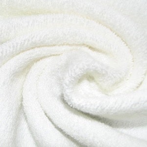 May include: White terry cloth fabric with a soft, fluffy texture. The fabric is tightly woven and has a smooth, even surface.