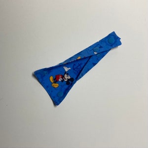 May include: Blue fabric strap with Mickey Mouse and anchor print. The strap has three blue snap buttons.