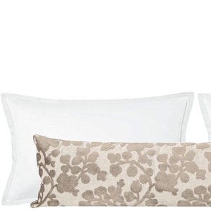 May include: Two white pillowcases with a brown patterned lumbar pillow in the center. The lumbar pillow has a floral design.