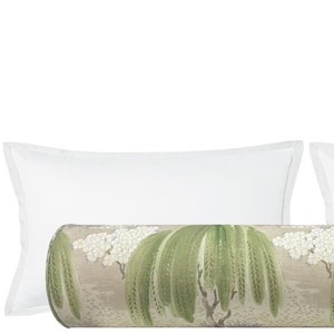 May include: A decorative bolster pillow with a green and white floral pattern. The pillow is surrounded by two white standard pillows.