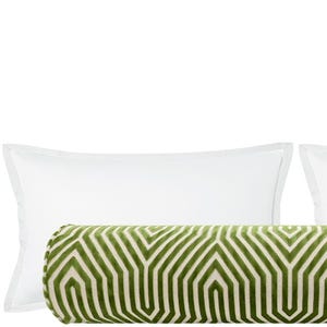 May include: A decorative pillow set featuring a cylindrical bolster pillow with a geometric green and cream pattern, flanked by two white rectangular pillows with a subtle border. The pillows are arranged on a white background.