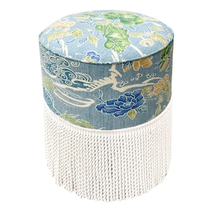 May include: A blue and white floral patterned ottoman with a white fringe around the bottom.