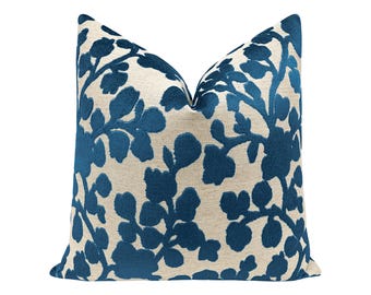 May include: A decorative throw pillow with a blue floral pattern on a cream background.